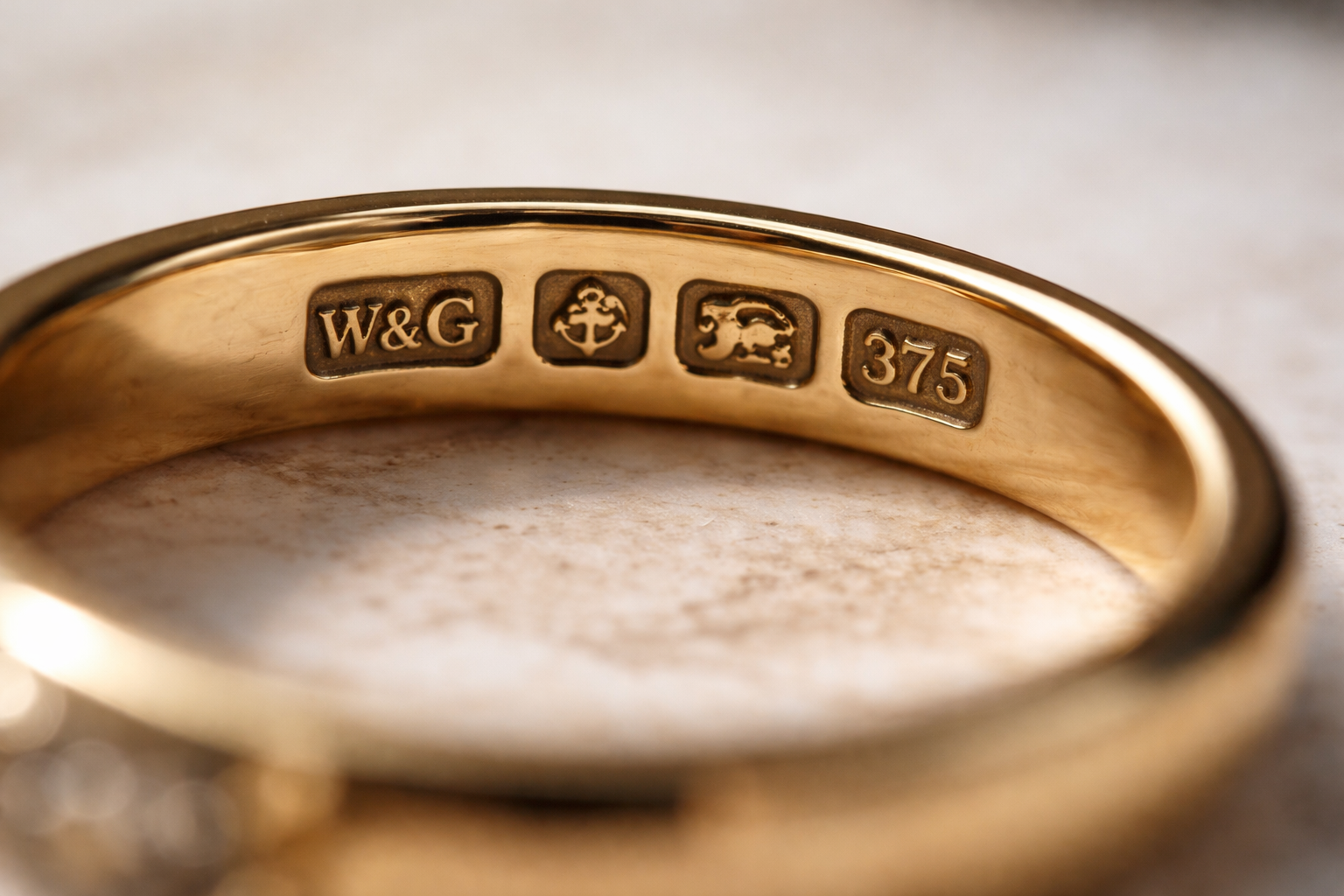 Close-up of UK gold hallmarks stamped on a ring shank